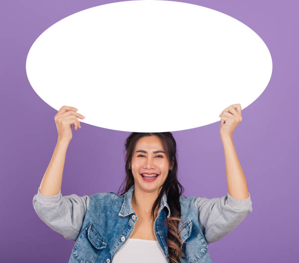 istock woman smiling excited wear denims hold empty speech bubble sign 1449315431