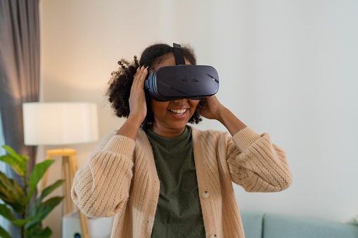 Woman wearing virtual reality headsets to watching concert while her sister control viewpoint on digital tablet