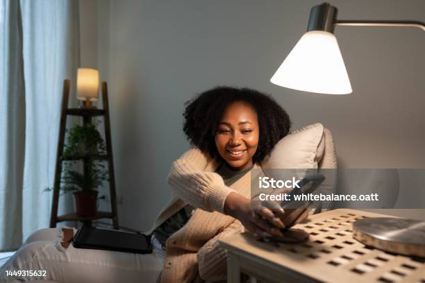 Woman Putting Her Smartphone On Wireless Charger Stock Photo - Download Image Now - Lighting Equipment, Illuminated, Domestic Life