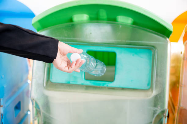 istock Business woman throwing empty plastic bottle water into recycle garbage trash 1449316930