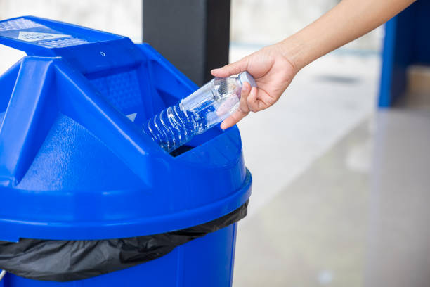 istock Close up female throwing empty bottle to trash 1449317035