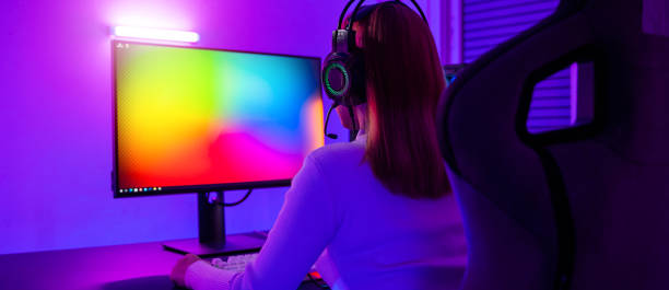 istock Asian professional gamer playing online video game on desktop computer PC have colorful neon LED lights 1449317143