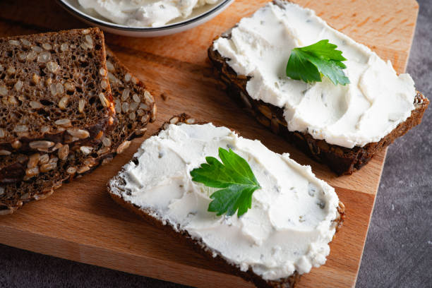 istock Rye bread with cream cheese on grey table. Whole grain rye bread with seeds 1449317811