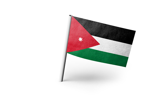 Small paper flag of Jordan pinned. Isolated on white background. Horizontal orientation. Close up photography. Copy space.