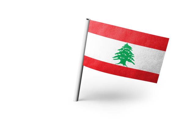 Small paper flag of Lebanon pinned. Isolated on white background. Horizontal orientation. Close up photography. Copy space.