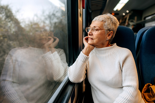 Senior woman enjoying a view while riding in a train