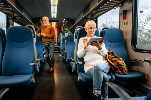 istock Senior woman using digital tablet while travelling by the train 1449322383
