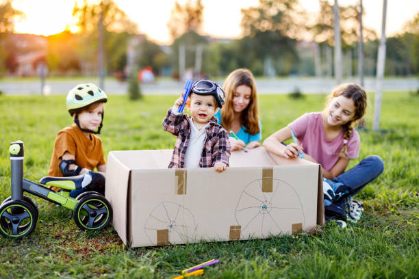 istock Children playing whit cardboard box in the nature 1449324447