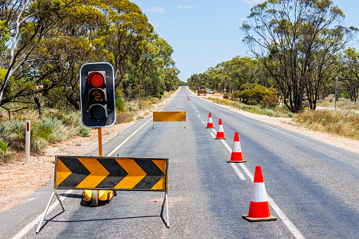 Red traffic light and stop sign at the road crossing