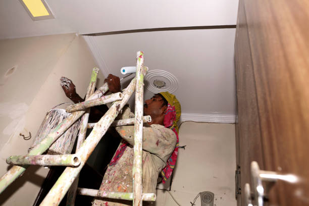 Painter painting the wall with roller and brush during Diwali festival portrait close up at home.