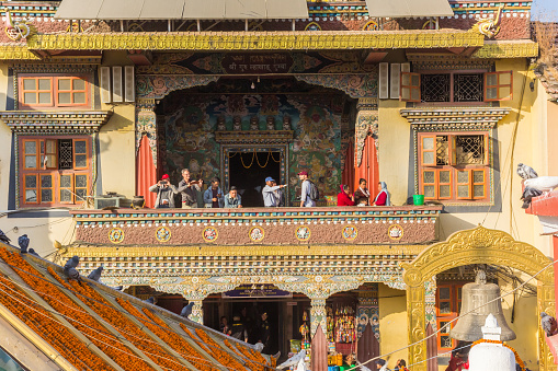 People at the balcony of a historic building at the Boudhanath stupa in Kathmandu, Nepal
