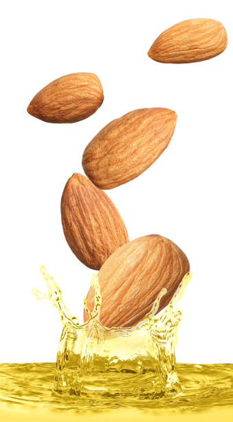 istock Tasty nuts falling into organic almond oil on white background. Vertical banner design 1449327949