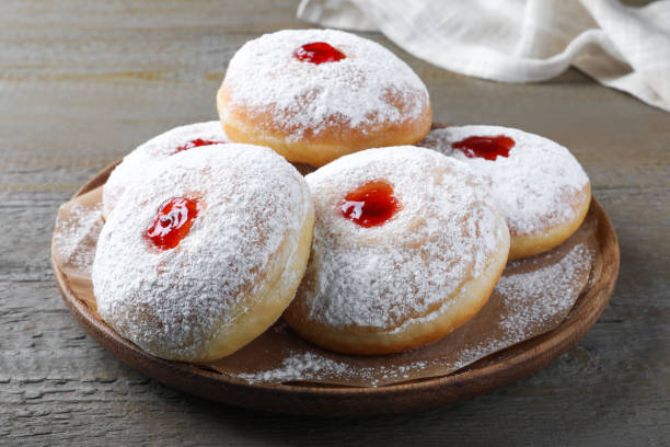 istock Delicious donuts with jelly and powdered sugar on wooden table 1449328183