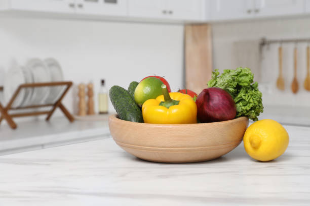 istock Bowl with fresh ripe vegetables and fruits on table in kitchen 1449329883