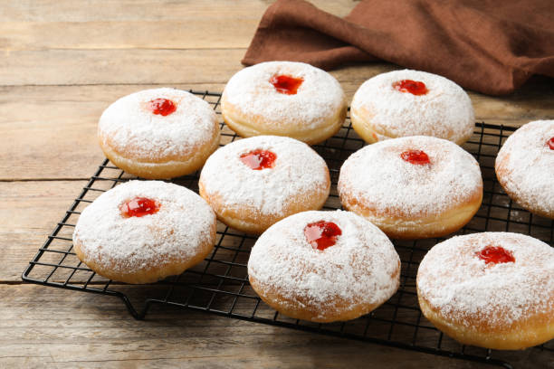 istock Many delicious donuts with jelly and powdered sugar on wooden table 1449330657