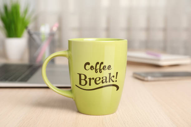 istock Mug with inscription Coffee Break on wooden table in office 1449333282