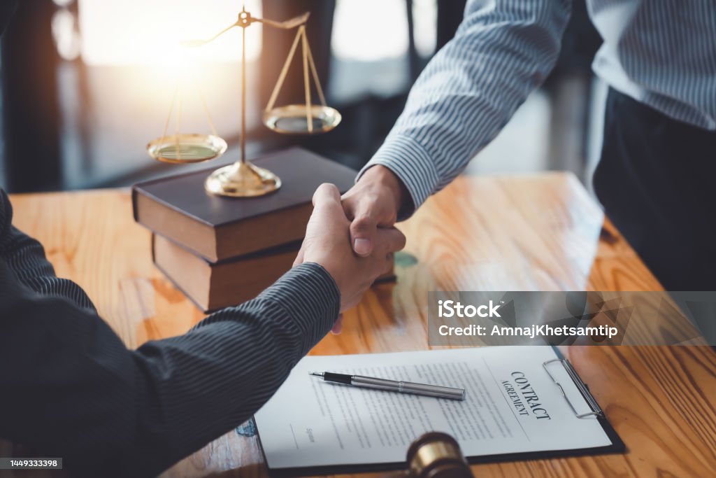 Businessman shaking hands partner lawyers or attorneys discussing a contract agreement. Legal System Stock Photo