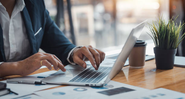istock Businessman sitting using laptop computer with document on the desk in the office. 1449333593