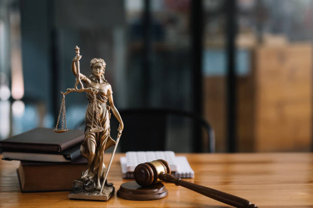 裁判官や弁護士の机の上に立つ正義の女性の像。 - 規則 ストックフォトと画像