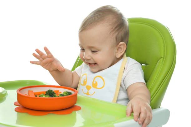 istock Cute little baby wearing bib while eating on white background 1449334691