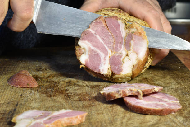 istock A wide knife cuts the meat on the board. 1449334713