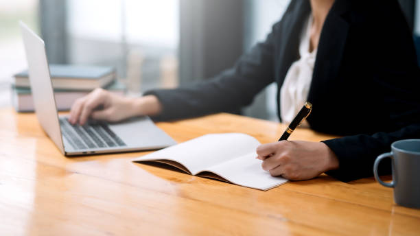 istock Businessman sitting using laptop computer with document on the desk in the office. 1449335080