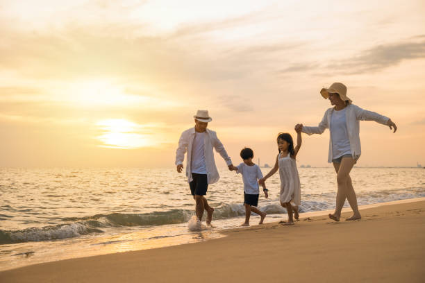 istock Happy family having fun running on a sandy beach at sunset time 1449335302