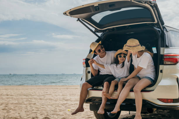 istock Dad, mom and daughter enjoying road trip sitting on back car 1449335331