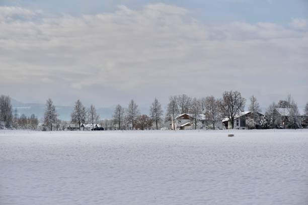 istock Snow-covered Bavaria. Blue clear sky, fields, forests and winter. Winter Upper Bavaria under the snow. A Bavarian village under the snow in December. 1449335717