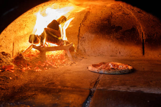 pizza gebacken im steinofen mit brennholz beheizt - back lit stock-fotos und bilder
