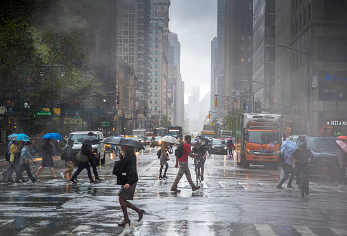 Daily life during a rainy day on the 40th street in Manhattan. Steam coming out from from the manholes in the background. New York City, Usa. Manhattan is the most densely populated borough of New York City.