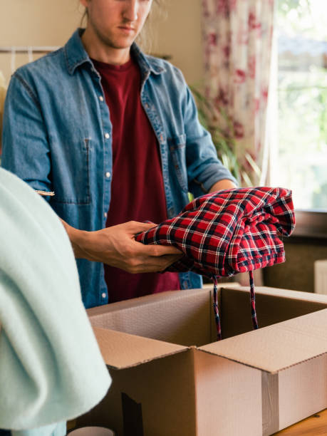 istock Man preparing cardboard box with used clothes 1449338176