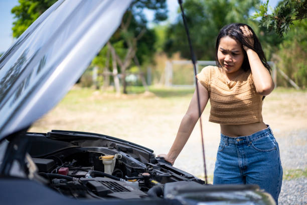 istock Worry young woman with broken down car on street. 1449339612