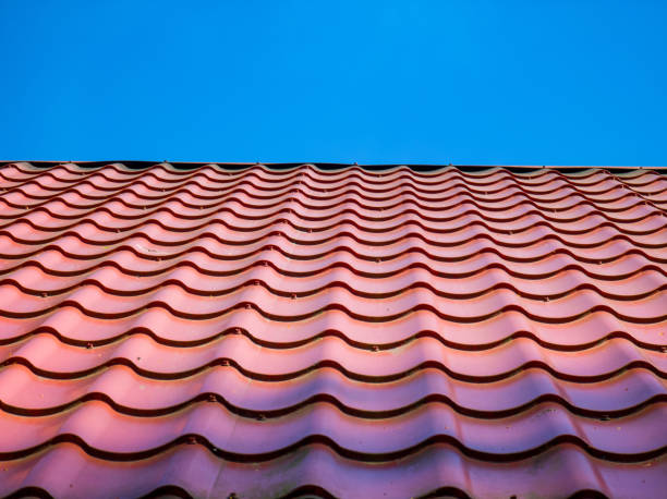 istock Red clay ceramic tiled roof. Blue sky. Close-up. 1449341616
