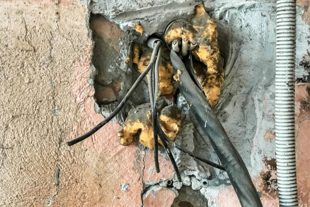 istock Close up abandoned electrical box with broken wires on ruined filthy wall. Dirty electric power distribution box on dirty textured wall in industry building. Concept of old equipment. Copy text space 1449346035