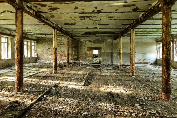 istock An abandoned interior Soviet military barracks in a military unit. Grunge abandoned ruined hall with shabby walls and sunlight from large windows. Grungy warehouse basement background. Copy text space 1449347172