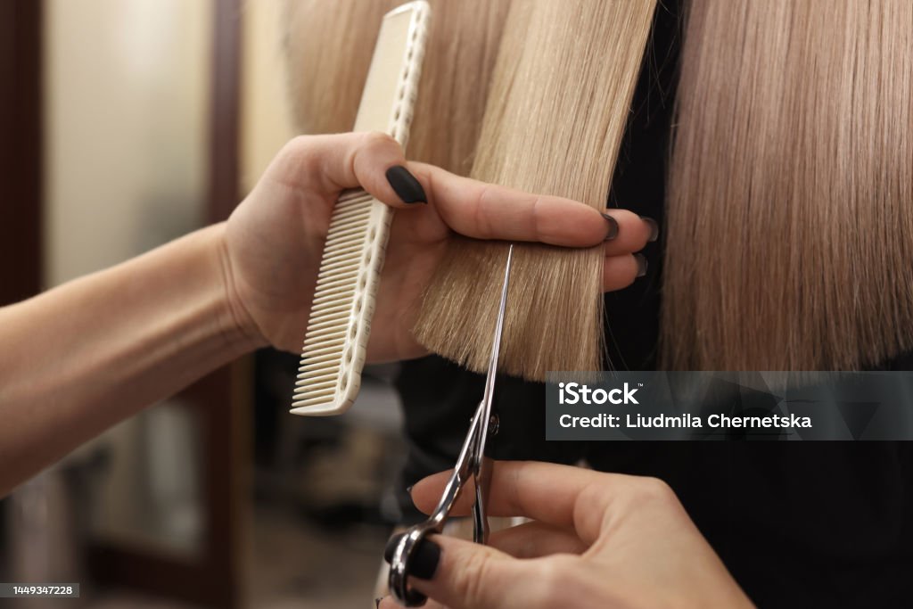 Professional hairdresser cutting woman's hair in salon, closeup Hairdresser Stock Photo