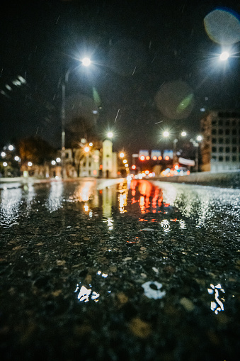 Close up view of a wet city street on a rainy night in city.