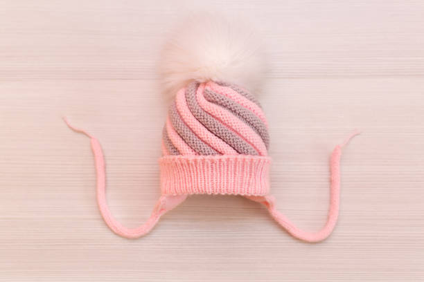 istock Pink children's knitted wool hat with a pompom, on a white background 1449350192