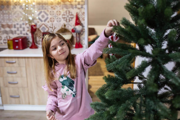 istock A cute girl enjoying decorating her Christmas tree 1449350351