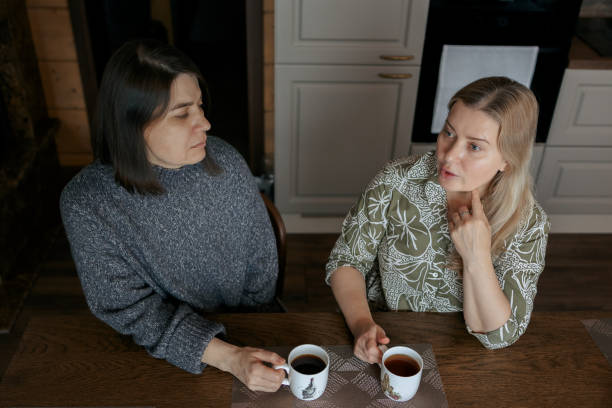 istock Two women talking at home. Girlfriends drinking cup of coffee in kitchen. 1449350643