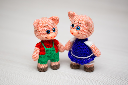 Knitted piglets toys for a child. A symbol of the New Year.
