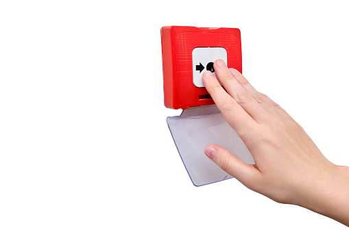Woman reaches for the fire alarm, hand turns on the call button for firefighters close-up, isolated on a white background. Red fire alarm in the home room and man hand