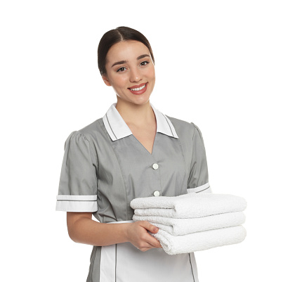 Portrait of young chambermaid with towels on white background