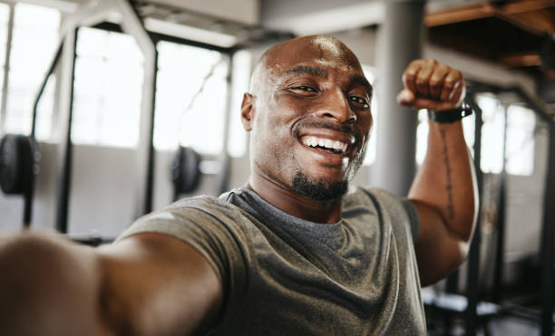 black man, strong and fitness selfie, gym and exercise portrait, after workout and weight training, happy and flexing arm. cardio, endurance and smile, sweat for sport and bicep photo, wellness. - flexing muscles fotos imagens e fotografias de stock