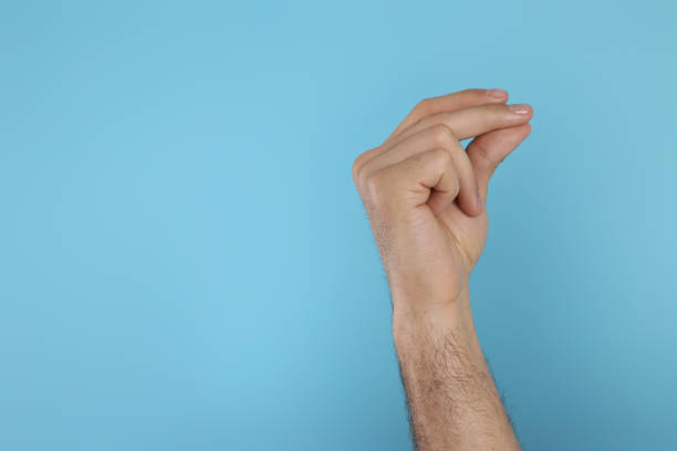 istock Man snapping fingers on light blue background, closeup of hand. Space for text 1449355209