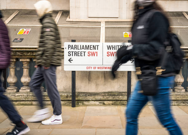 people passing a sign for parliament street and whitehall in london - go palavra inglesa imagens e fotografias de stock