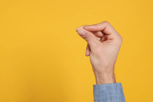 istock Man snapping fingers on yellow background, closeup of hand. Space for text 1449355944