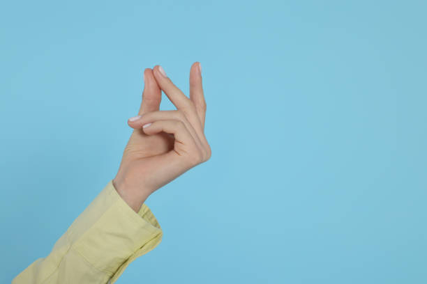 woman snapping fingers on light blue background, closeup of hand. space for text - copy space left imagens e fotografias de stock