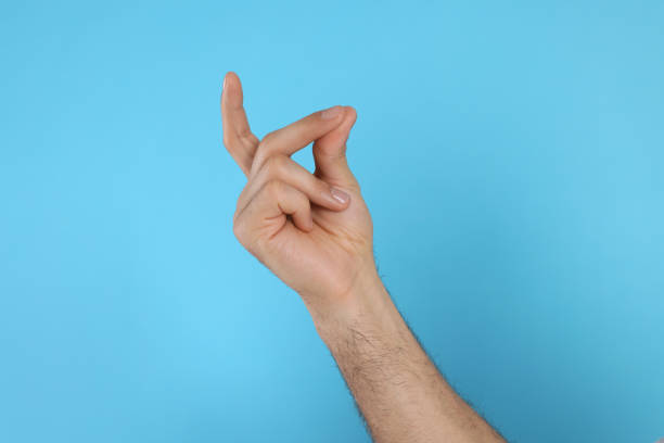 istock Man snapping fingers on light blue background, closeup of hand 1449357318